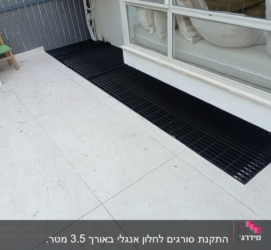 מסגרת מתכת שחורה ליד חלון זכוכית גדול